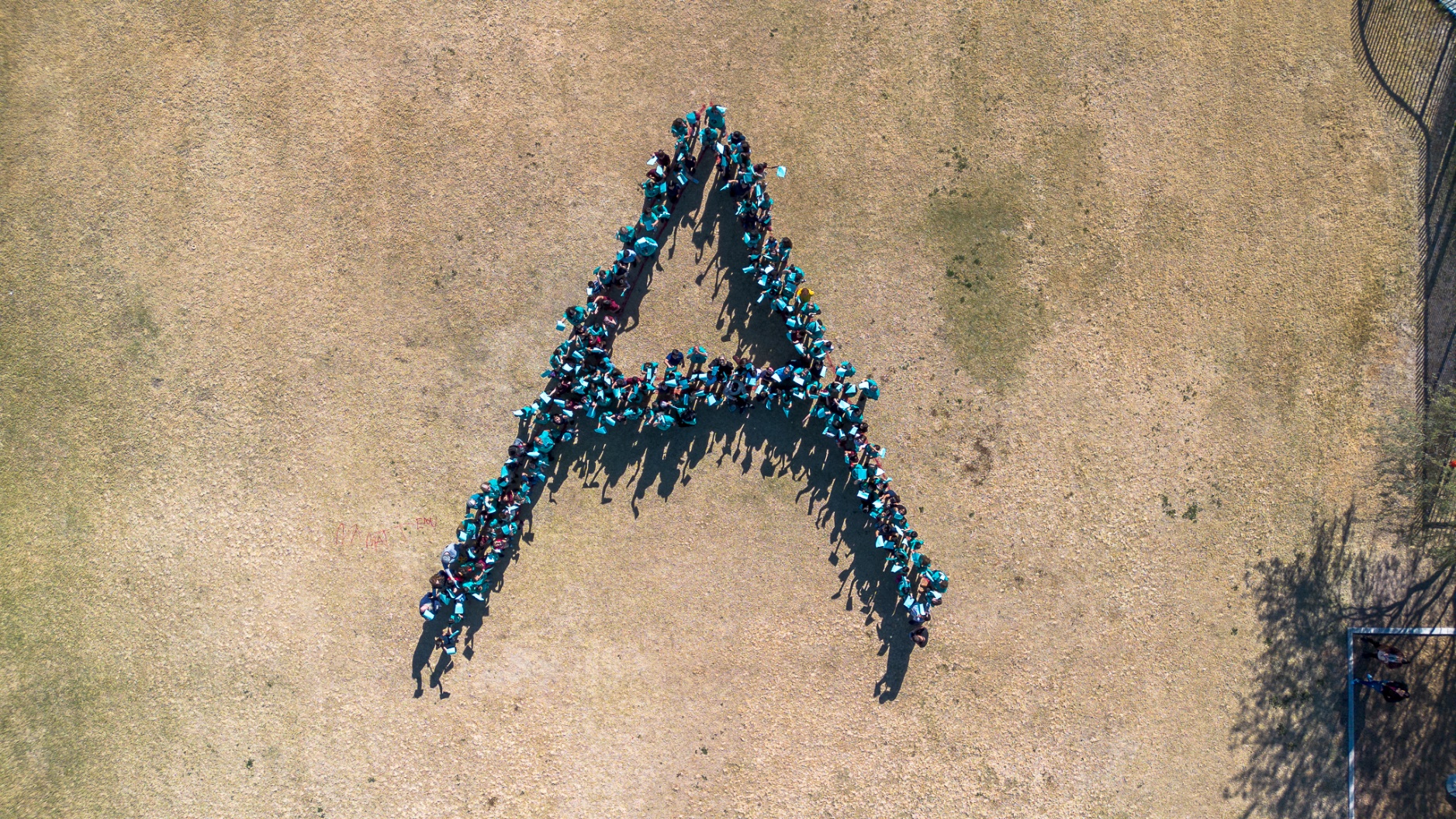 Drone photo of students and staff making the letter A on the field