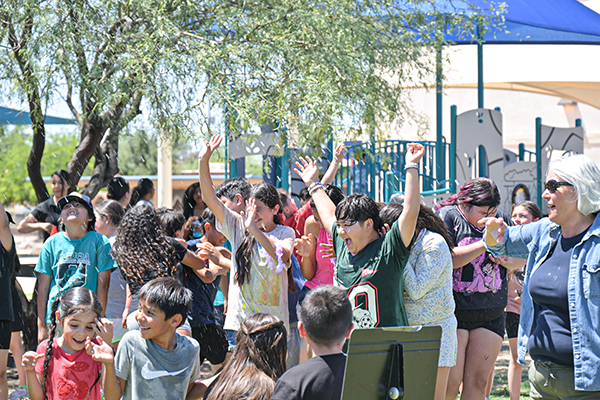 Students shriek with joy as they get sprayed with a hose